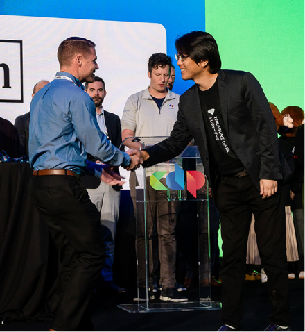 Attendees shaking hands on the awards stage